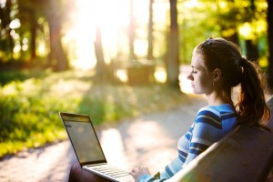 Young woman using laptop in park